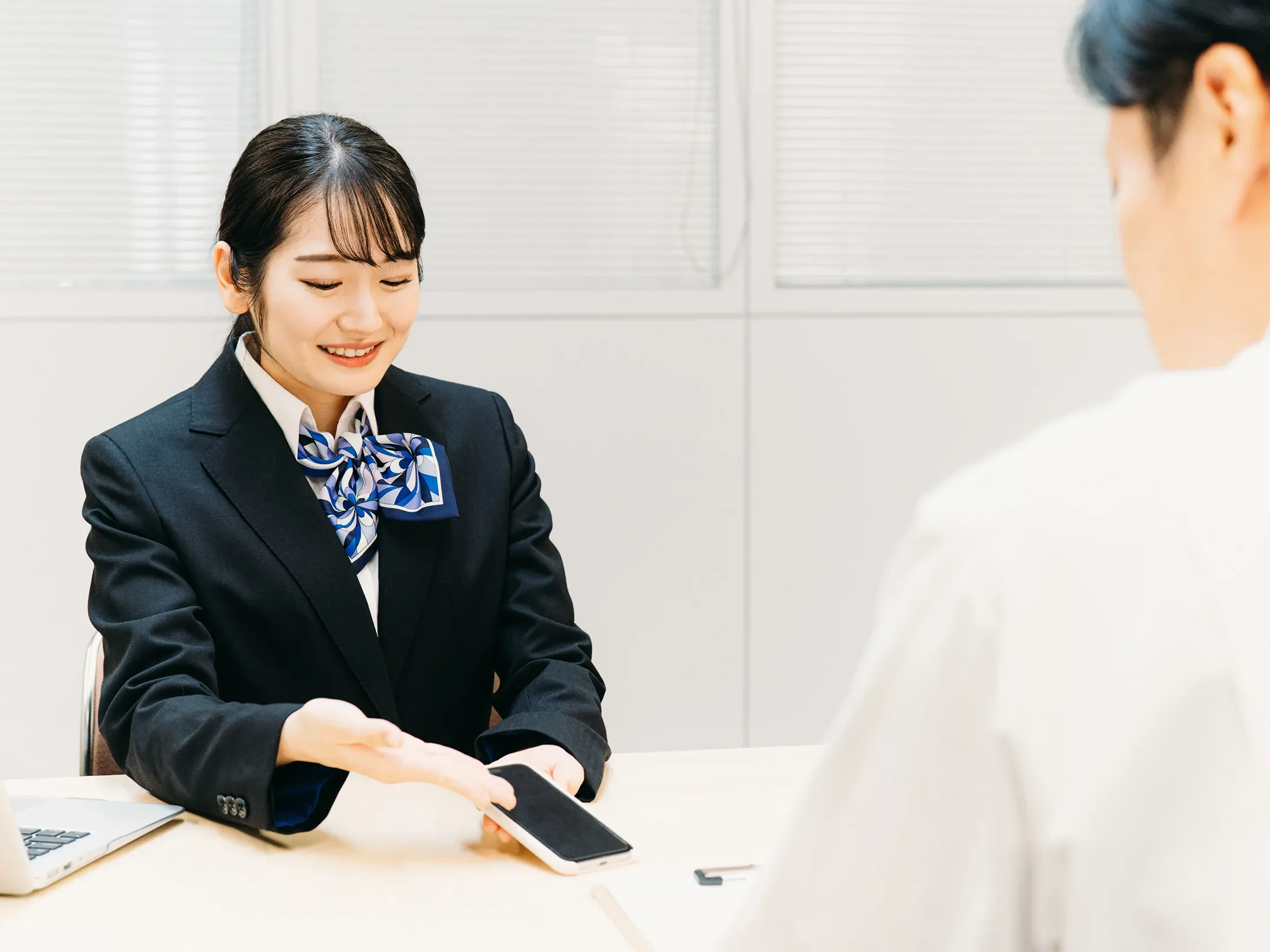 店舗スタッフがスマートフォンを案内する様子